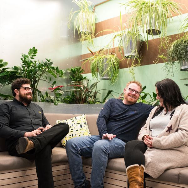 Three of the Chick team talking on a sofa in the office